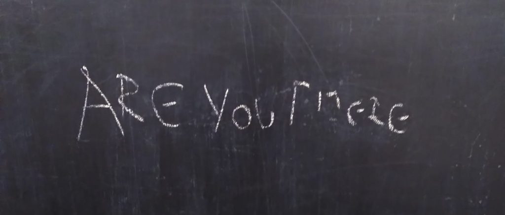 A blackboard with an unclear message chalked on it. "Are you FMELG"